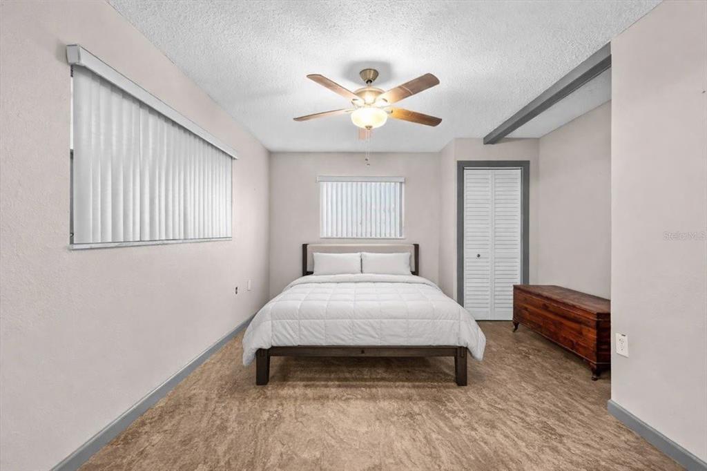 4880 Shell Stream Boulevard New Port Richey, FL 34652 - Photo 12 of 25 a bedroom with a bed and a chandelier