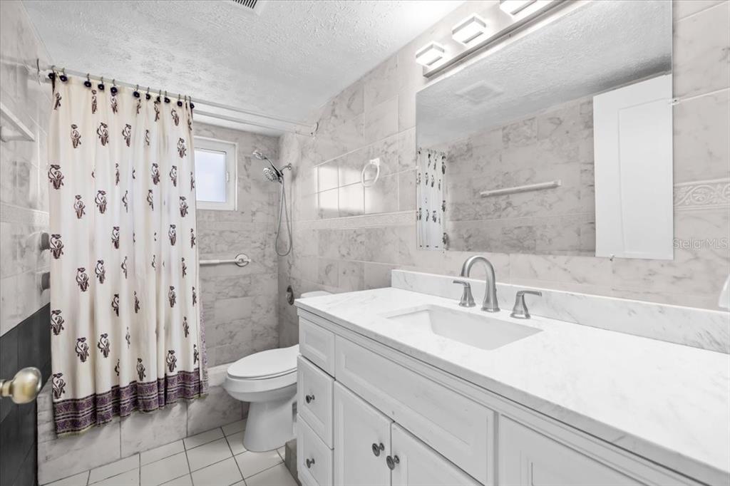 4880 Shell Stream Boulevard New Port Richey, FL 34652 - Photo 14 of 25 a bathroom with a sink a toilet and shower