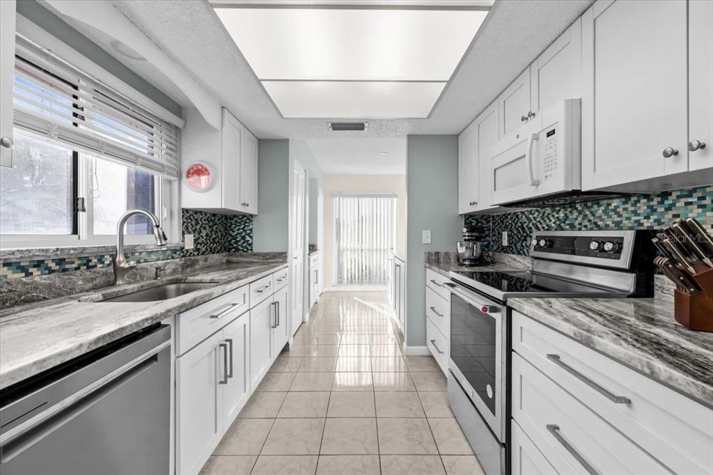 4880 Shell Stream Boulevard New Port Richey, FL 34652 - Photo 19 of 57 a large kitchen with stainless steel appliances granite countertop a stove and a sink