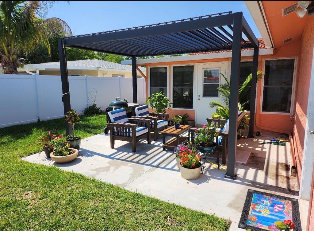 4880 Shell Stream Boulevard New Port Richey, FL 34652 - Photo 6 of 25 a view of a patio with table and chairs potted plants with wooden floor and fence