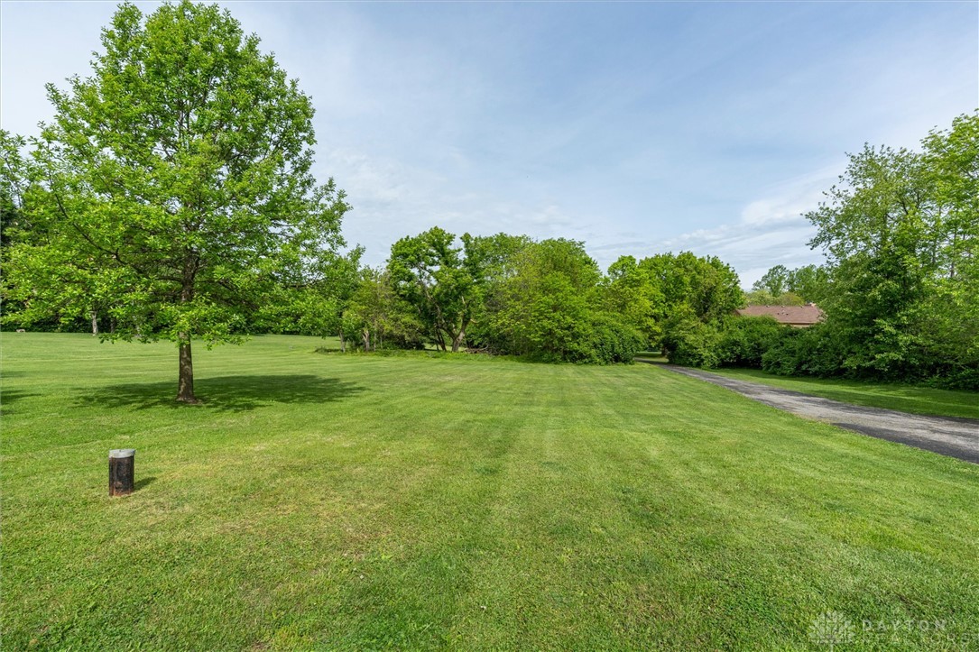 2165 Stewart Road Xenia, OH 45385 - Photo 49 of 59 Expansive green yard with mature trees offers serene outdoor living.