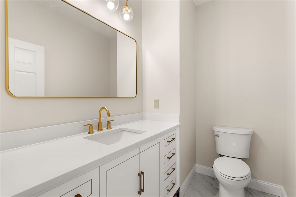 140 York Street Canton, MA 02021 - Photo 14 of 27 a bathroom with a toilet a sink a mirror and vanity