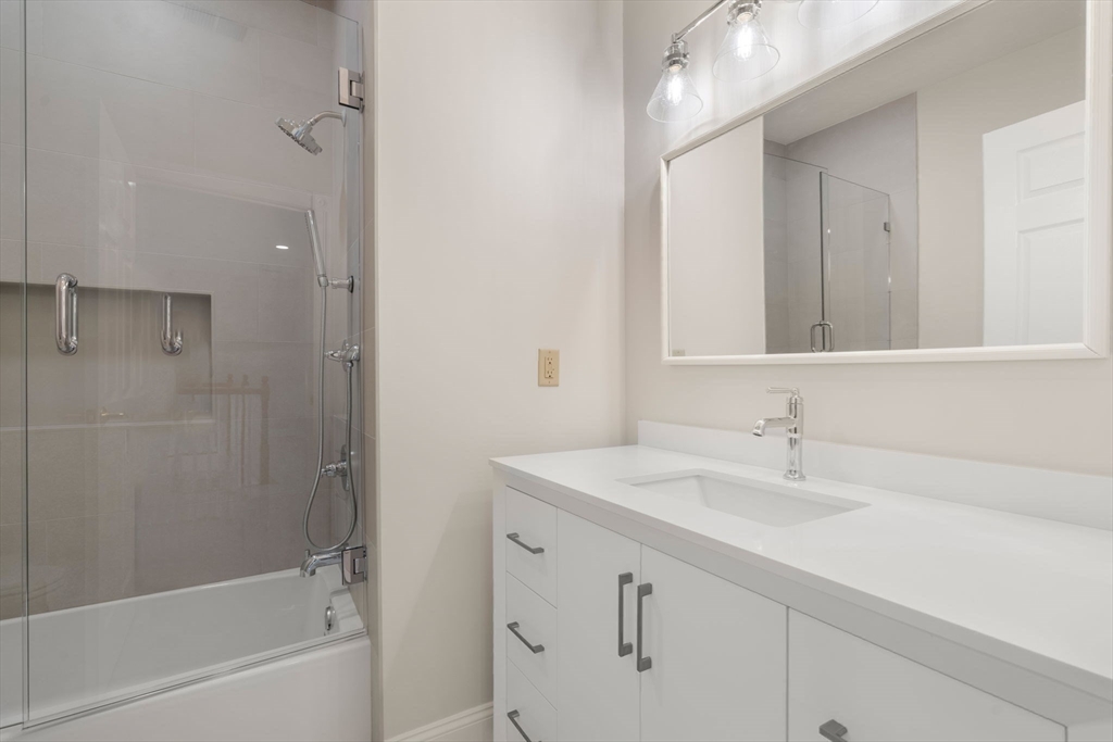 140 York Street Canton, MA 02021 - Photo 20 of 27 a bathroom with a sink double vanity mirror and a bathtub