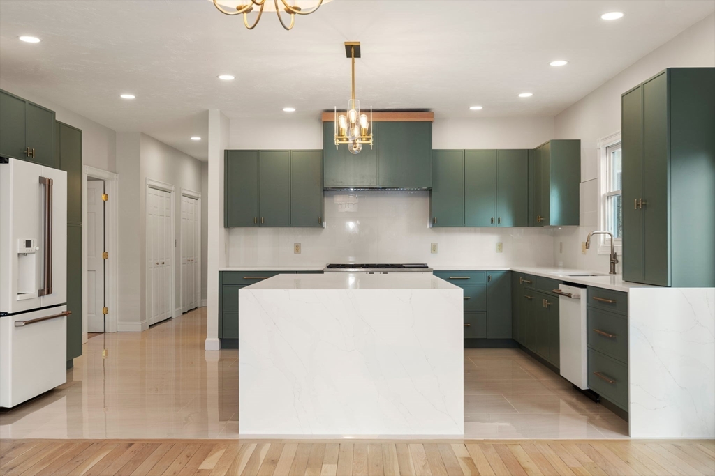 140 York Street Canton, MA 02021 - Photo 4 of 27 a large kitchen with stainless steel appliances kitchen island a refrigerator oven a sink with a fireplace and wooden floor