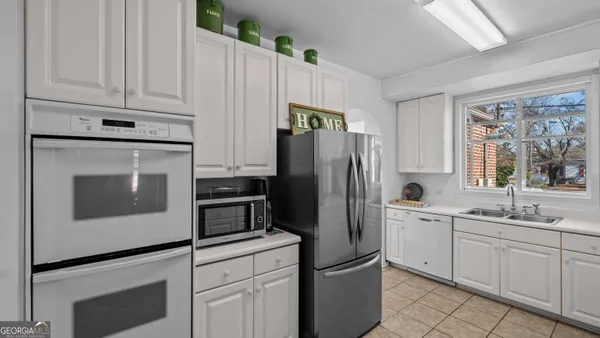 a kitchen with white cabinets and stainless steel appliances