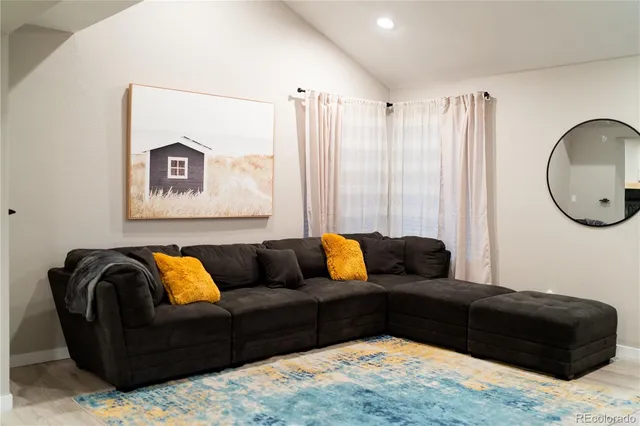 a living room with furniture and a mirror