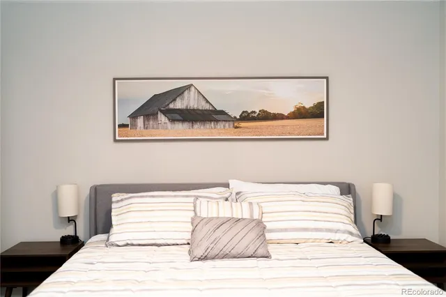 a bedroom with a bed and a painting on the wall