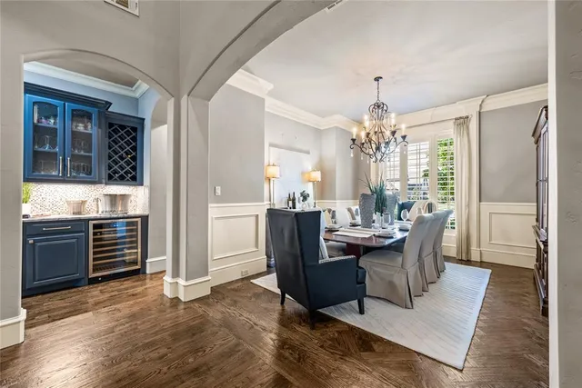 a dining room with furniture a chandelier and wooden floor