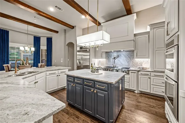 a kitchen with stainless steel appliances granite countertop a stove a sink dishwasher and a refrigerator