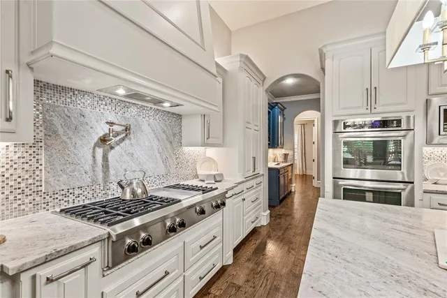 a kitchen with stainless steel appliances granite countertop a stove and a refrigerator