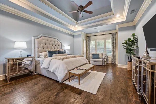 a bedroom with a large bed and a flat tv screen on dresser