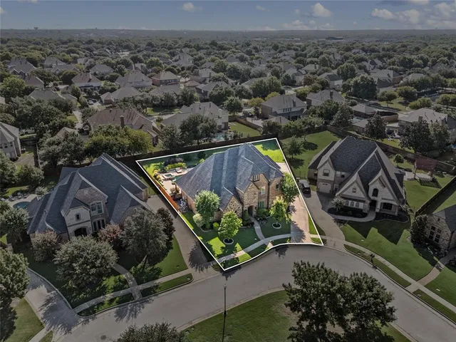 a view of a big house in a big yard with palm trees