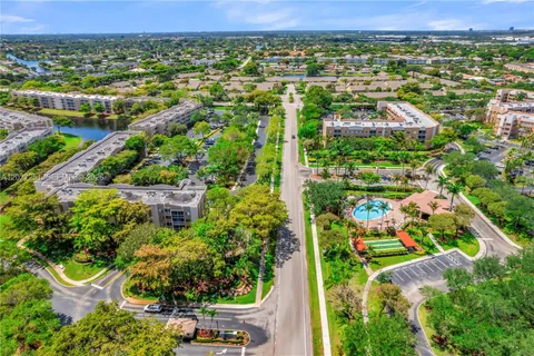 an aerial view of residential houses with outdoor space and trees