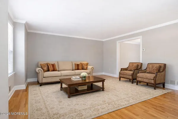 a living room with furniture and a wooden floor