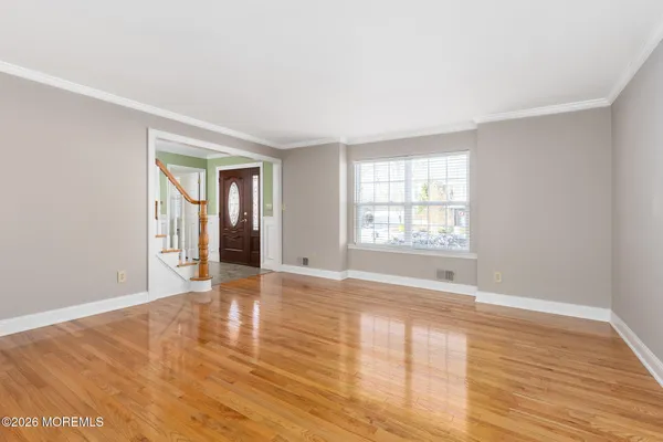 a view of empty room with wooden floor