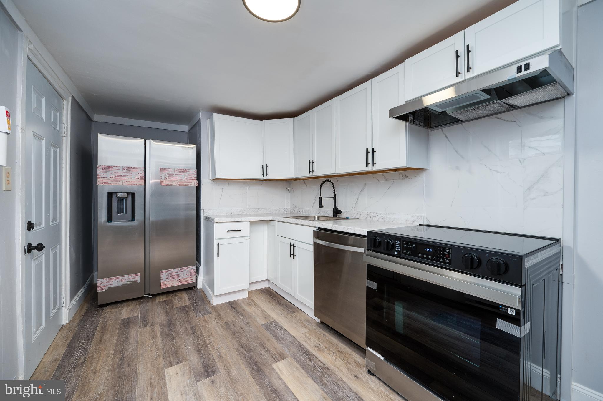 1724 Cotton Street Reading, PA 19606 - Photo 8 of 29 a kitchen with a stove a refrigerator and cabinets
