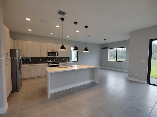 a kitchen with stainless steel appliances granite countertop a sink and a wooden cabinets