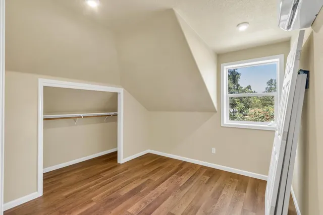 a view of empty room with wooden floor and window