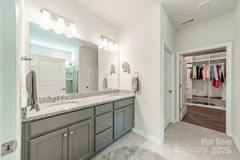 a en suite bathroom with a granite countertop sink and a mirror