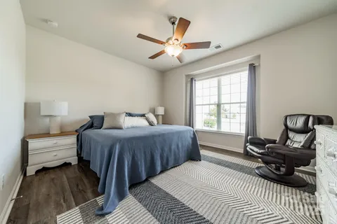 a bedroom with a bed a couch and a window