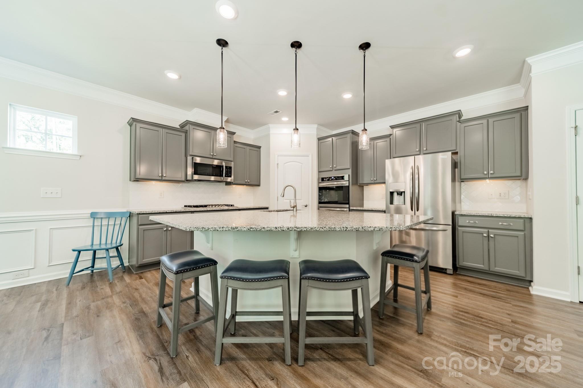 508 Vermeer Court Mount Holly, NC 28120 - Photo 6 of 24 a kitchen with stainless steel appliances kitchen island granite countertop a table chairs microwave and sink