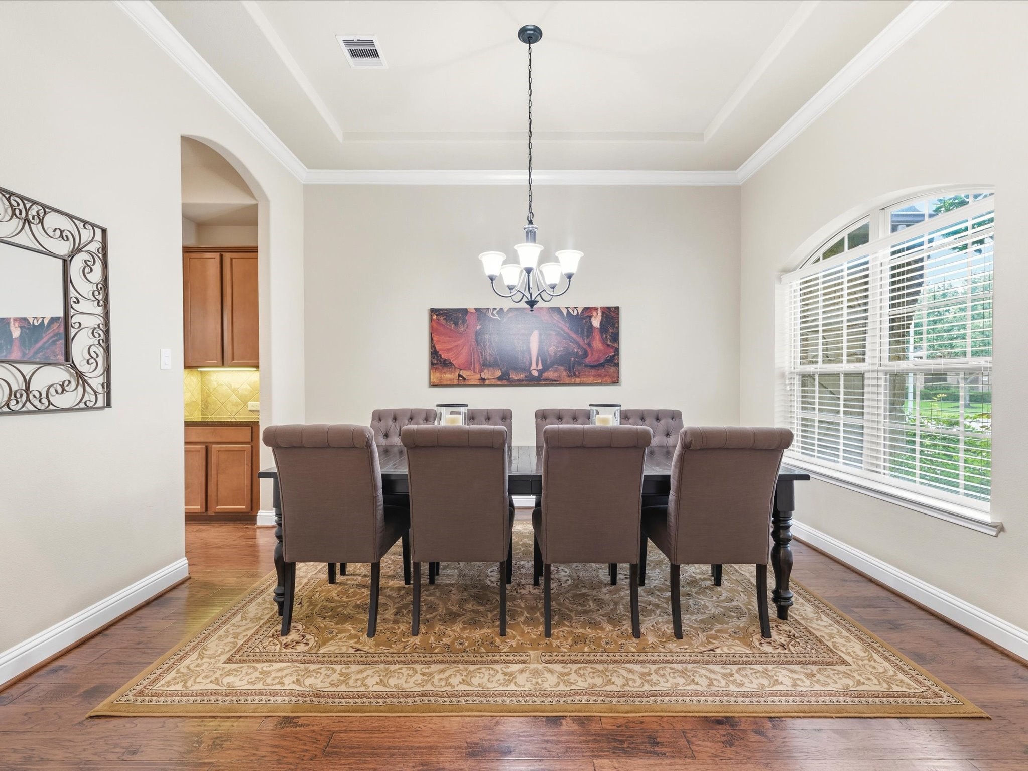 3907 Randle Ridge Court Fulshear, TX 77441 - Photo 5 of 46 This dining room features elegant wood flooring, area for a large table, and abundant natural light from a large west facing windows. A decorative light fixture and high ceiling with decorative details tasteful enhance the room's classic appeal.