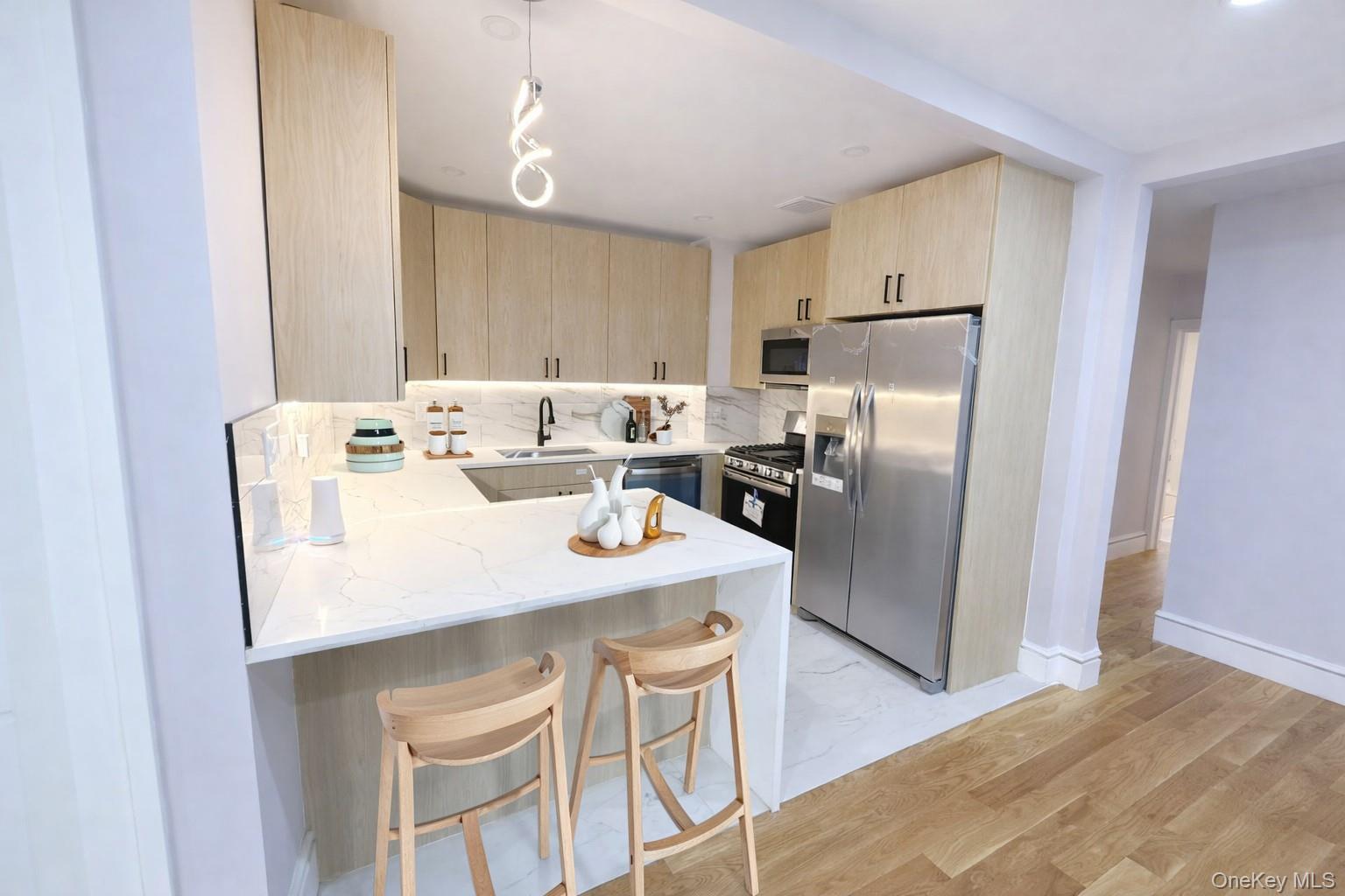 108-39 Union Turnpike Queens, NY 11375 - Photo 2 of 13 a kitchen with stainless steel appliances granite countertop a refrigerator a stove a sink and white cabinets with wooden floor