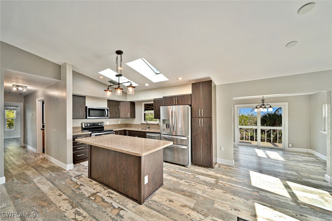 812 Rabbit Road Sanibel, FL 33957 - Photo 4 of 49 a large kitchen with stainless steel appliances kitchen island granite countertop a refrigerator oven a sink dishwasher and white cabinets with wooden floor