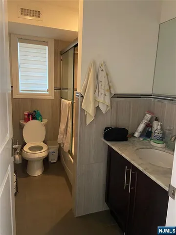 a bathroom with a sink a toilet and a window