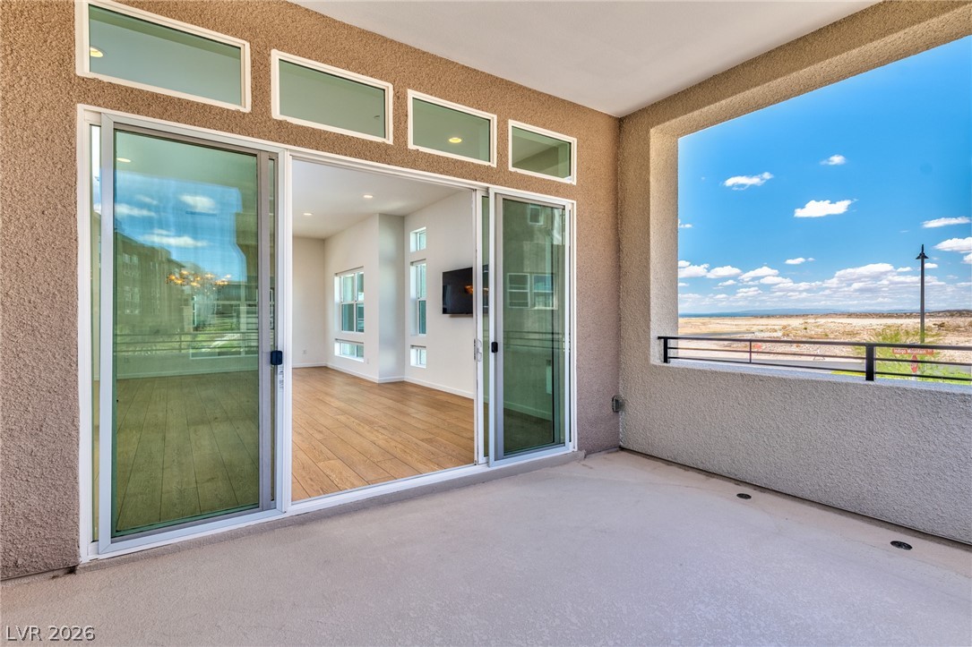 3327 Esker Rdg Avenue Henderson, NV 89044 - Photo 9 of 24 An inviting private patio extends from the open-concept living space, offering breathtaking views of the distant landscape.