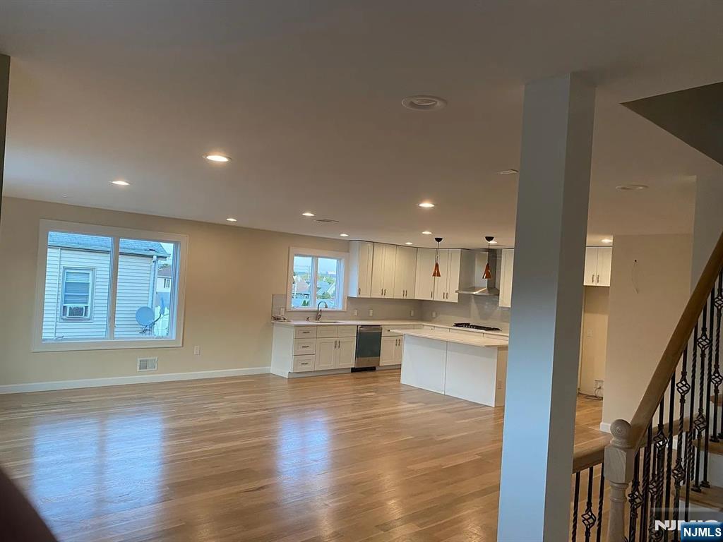 353 Hoboken Road Carlstadt, NJ 07072 - Photo 11 of 12 a open kitchen with white cabinets and wooden floor