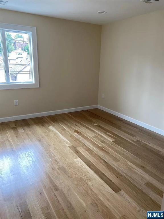 353 Hoboken Road Carlstadt, NJ 07072 - Photo 7 of 12 an empty room with wooden floor and windows