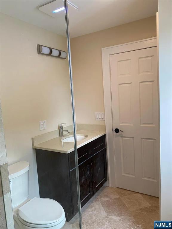 353 Hoboken Road Carlstadt, NJ 07072 - Photo 9 of 12 a bathroom with a sink a toilet a vanity and mirror