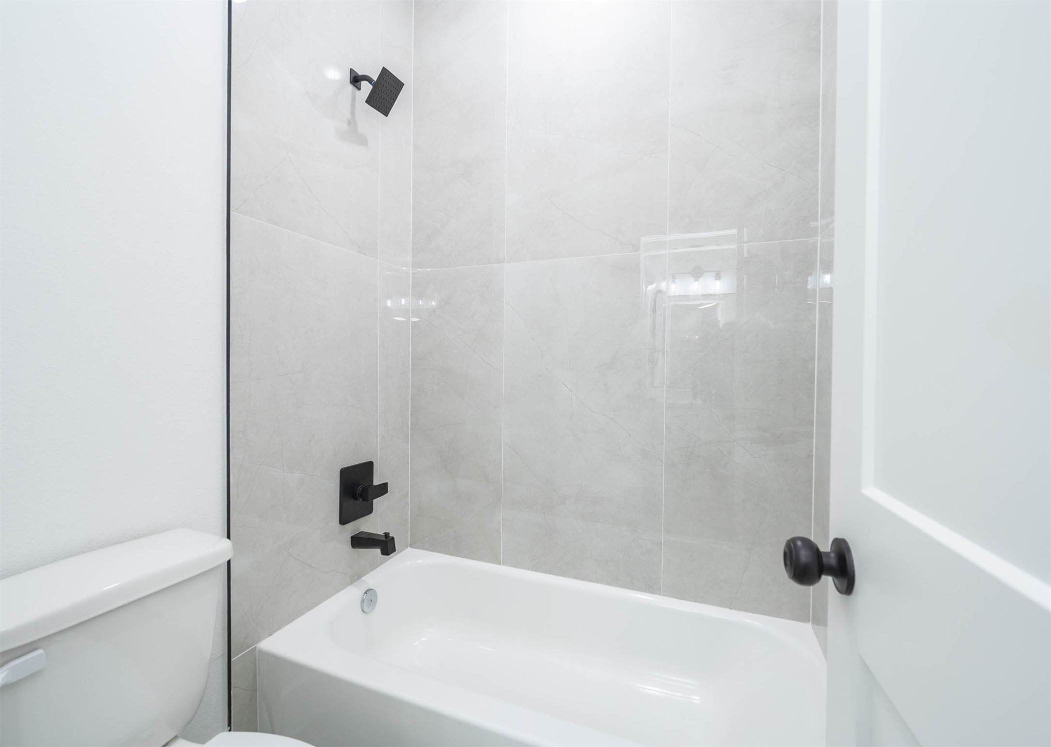 1515 Euel Street Houston, TX 77009 - Photo 23 of 34 Modern shower and bath combination with sleek tilework and stylish fixtures.