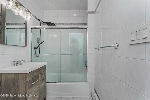 a bathroom with a shower sink and mirror