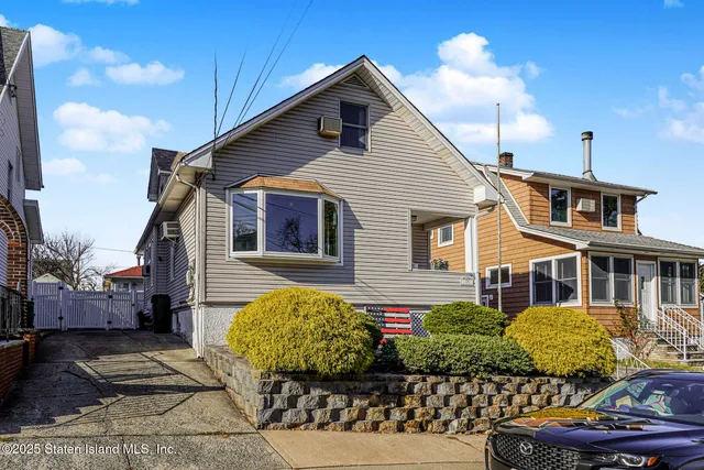 a view of a house with a yard and potted plants