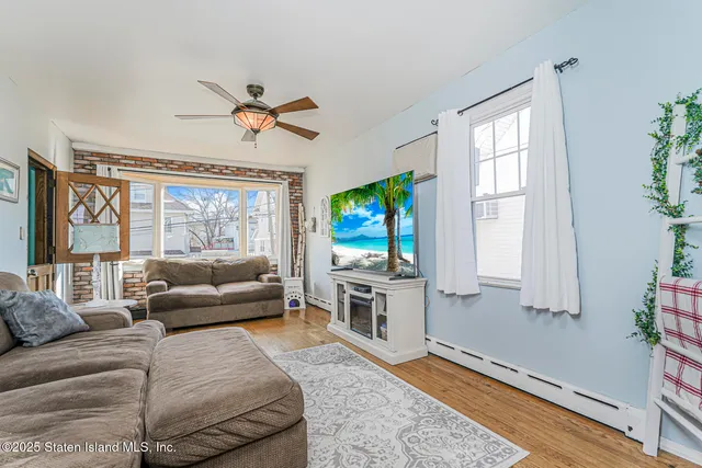 a living room with furniture a flat screen tv and a large window