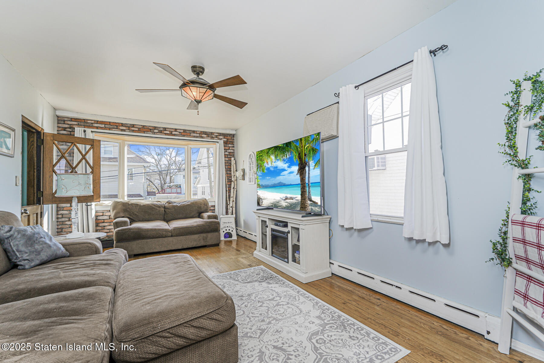 334 Neal Dow Avenue Staten Island, NY 10314 - Photo 6 of 37 a living room with furniture a flat screen tv and a large window