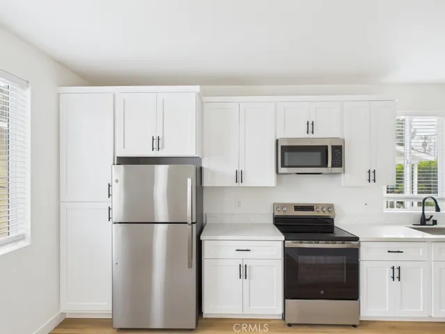 a kitchen with stainless steel appliances a refrigerator sink and microwave
