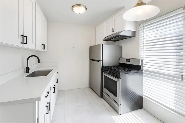 a kitchen with stainless steel appliances granite countertop a sink and a stove