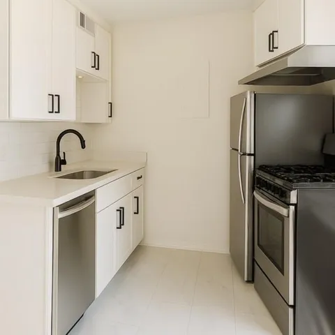 a kitchen with white cabinets and white appliances
