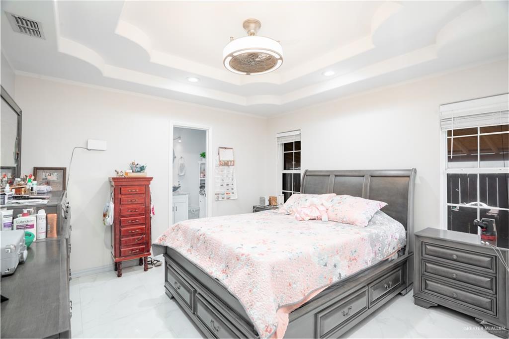 3006 Gabriel Street Mission, TX 78574 - Photo 29 of 34 a bedroom with a bed and a chandelier