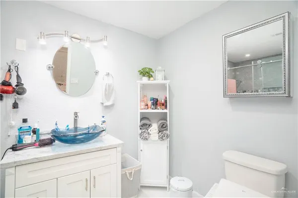 a bathroom with a sink a toilet and a mirror