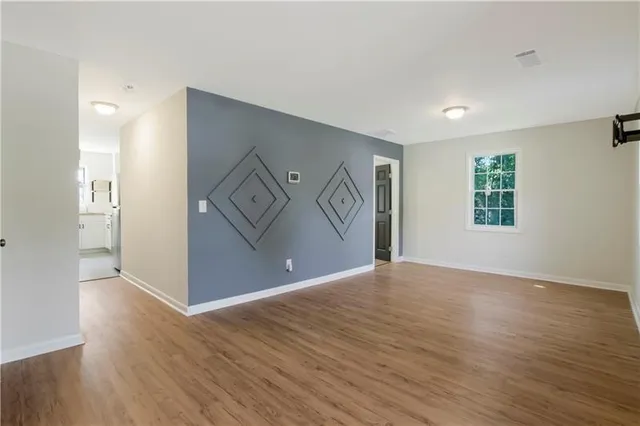 a view of empty room with wooden floor