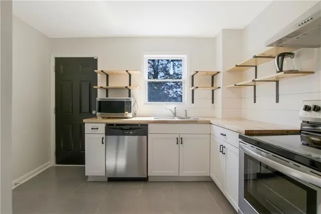 a kitchen with stainless steel appliances granite countertop a stove and a sink