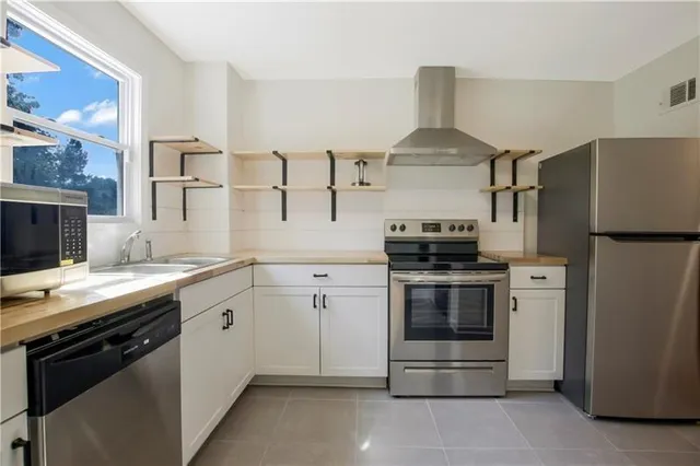 a kitchen with stainless steel appliances granite countertop a stove and a refrigerator