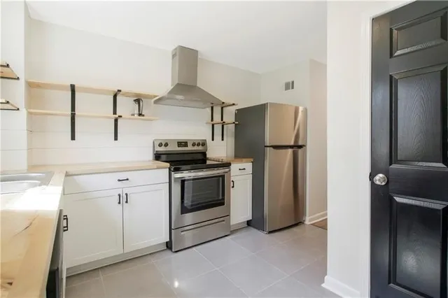 a kitchen with stainless steel appliances a refrigerator sink and stove