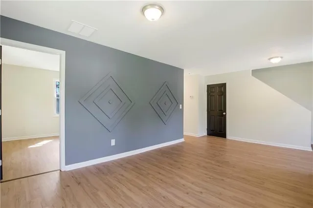 a view of an empty room with wooden floor