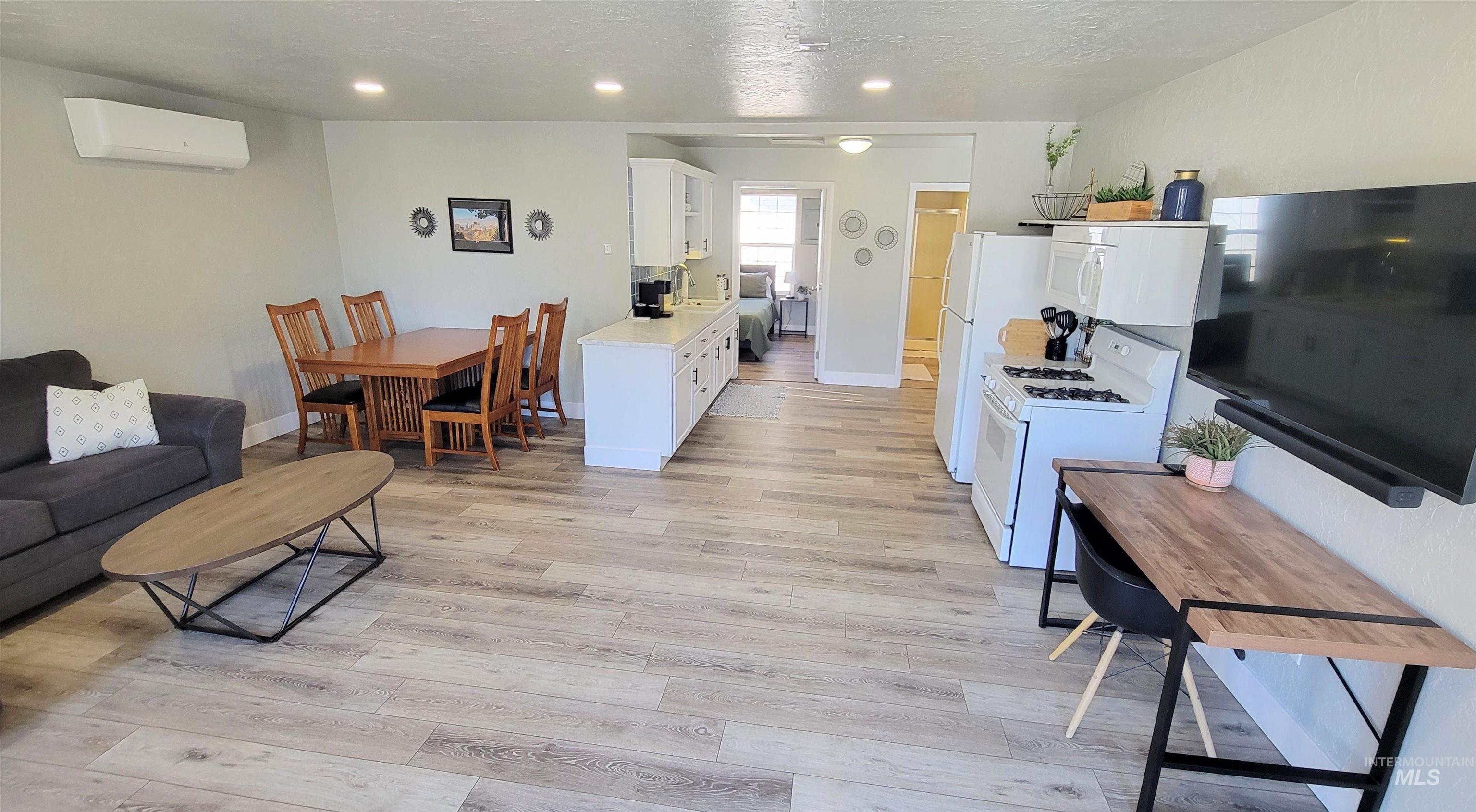 814 Baker Street Boise, ID 83706 - Photo 15 of 26 Open-concept living space featuring wood-finish flooring, recessed lighting, and a white kitchen with a gas range