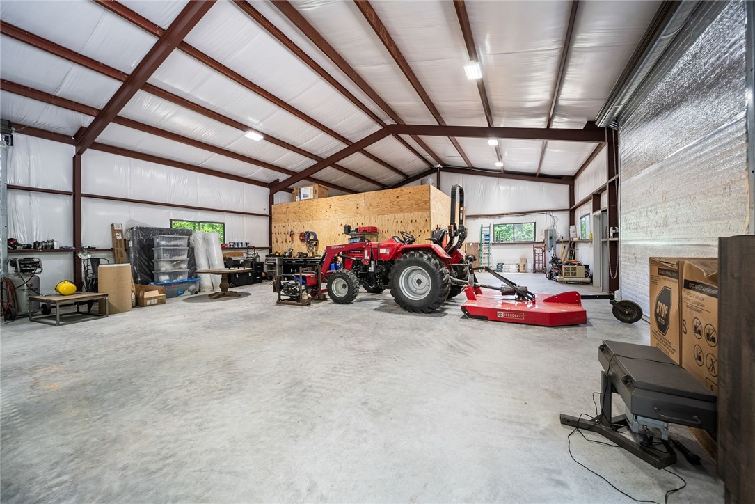 425 Barnhardt Road Timbo, AR 72680 - Photo 60 of 60 Spacious metal-framed structure featuring a high ceiling, polished concrete flooring, a large roll-up entry door, multiple windows, and integrated ceiling lighting